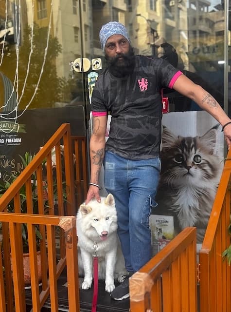 Sucha Singh, Senior Groomer at Comb & Collar, gently grooming a dog